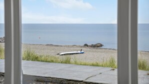 Une vue d’une plage avec une planche de surf posée sur le sable.