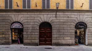 Un immeuble comptant deux devantures de magasin, l’une portant l’enseigne « Dolci Tentazioni » et l’autre « Lavanderia Europa ».