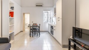 Una cocina moderna con comedor, televisor y estantería.