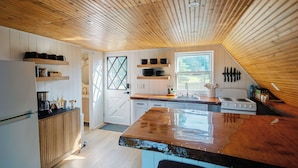 Een keuken met houten kastjes, een groot eiland en een raam.