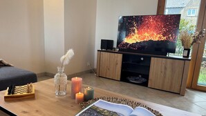 A living room with a wooden coffee table, a chessboard, candles, and a magazine. - Brise Marine by Interhome (Cancale)