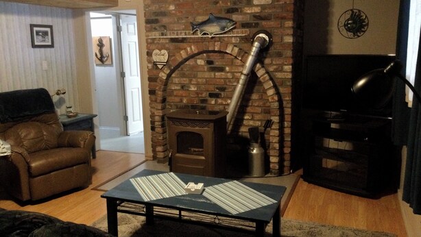 A cozy living room with a brick fireplace, a leather sofa, and a coffee table. - Sea Shell Inn. A cozy hideaway (Duncan)