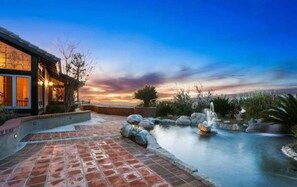 A modern building with a stone pathway leading to a water feature. - Majestic Anaheim Panorama Hill Home With Sunset (Anaheim)