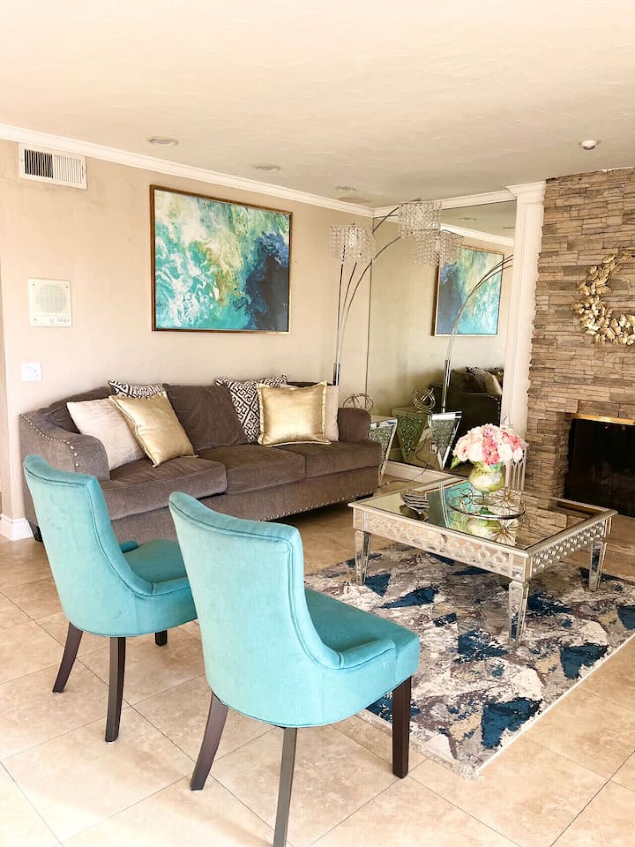 A living room with a sofa, two chairs, a coffee table, and artwork on the walls.