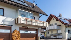 A two-story house with a balcony, a garage, and solar panels on the roof. - Apartment 'Haus Gisela Berger' with Shared Terrace, Shared Garden and Balcony (Dachsberg)