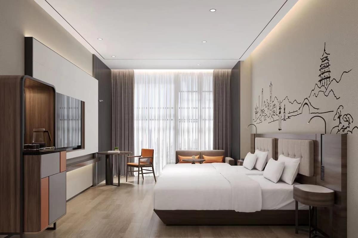 Een moderne hotelkamer met een groot bed, een bureau, een stoel en een televisie.