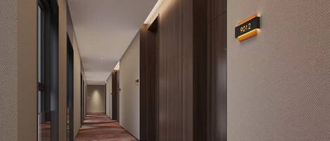 A modern hotel hallway with a carpeted floor, wooden doors, and a sign indicating room number 9012.