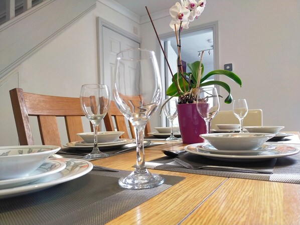 A dining table set for a meal, complete with a potted plant and a comfortable chair.