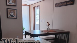Eine Küchenzeile mit Marmorarbeitsplatte, Holzschränken, gerahmten Kunstwerken an der Wand und einem 'Welcome'-Schild.