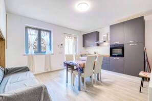A compact living space with a kitchenette, a dining area, and a sofa.