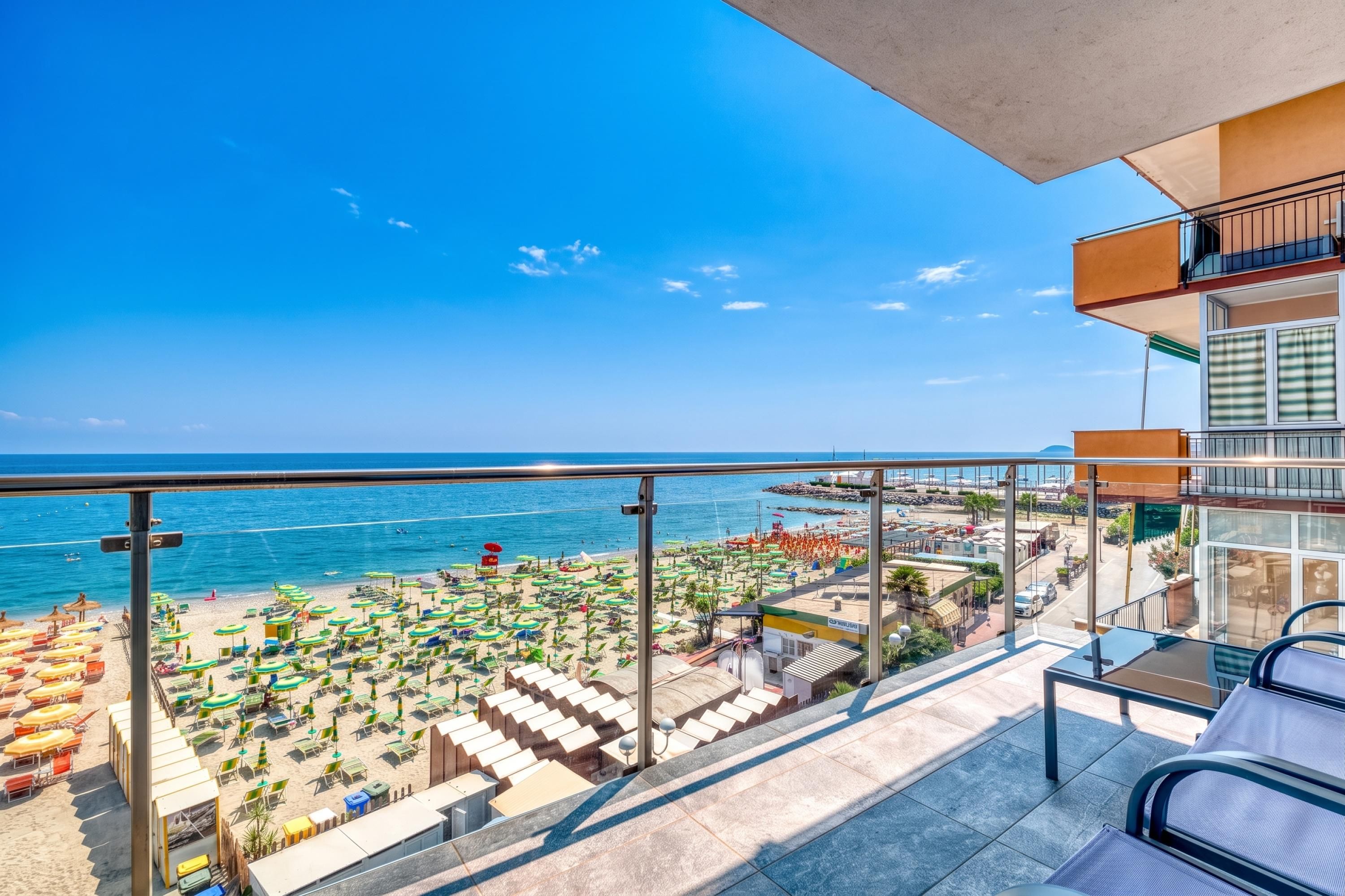 A balcony with a view of a beach and the sea.
