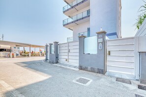 A modern building with a gated entrance, a clear sky, and a visible sign with the number 43. - Le Lanterne 1 - Luxury Apartments, Borghetto Santo Spirito, Italy (Borghetto Santo Spirito)