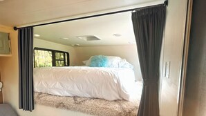 Une chambre à coucher de taille réduite, comprenant un lit, un bureau et une chaise.