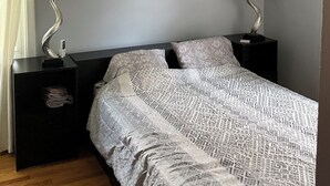 A bedroom with a bed, two bedside tables with lamps, a ceiling fan, and a wall-mounted artwork. - 3BR home 20’ Dtn Detroit, near Corewell Health Hos, Meijer’s  Major Bus Routes (Detroit)