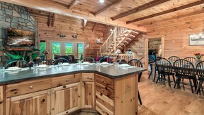 A spacious kitchen with a stone accent wall, wooden cabinetry, and a large island with seating.