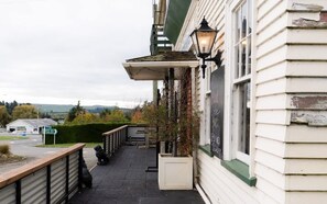 A building with a covered outdoor seating area, a street lamp, and a sign indicating a nearby location. - Weka Pass Cottages 2 by Tiny Away (Waikari)