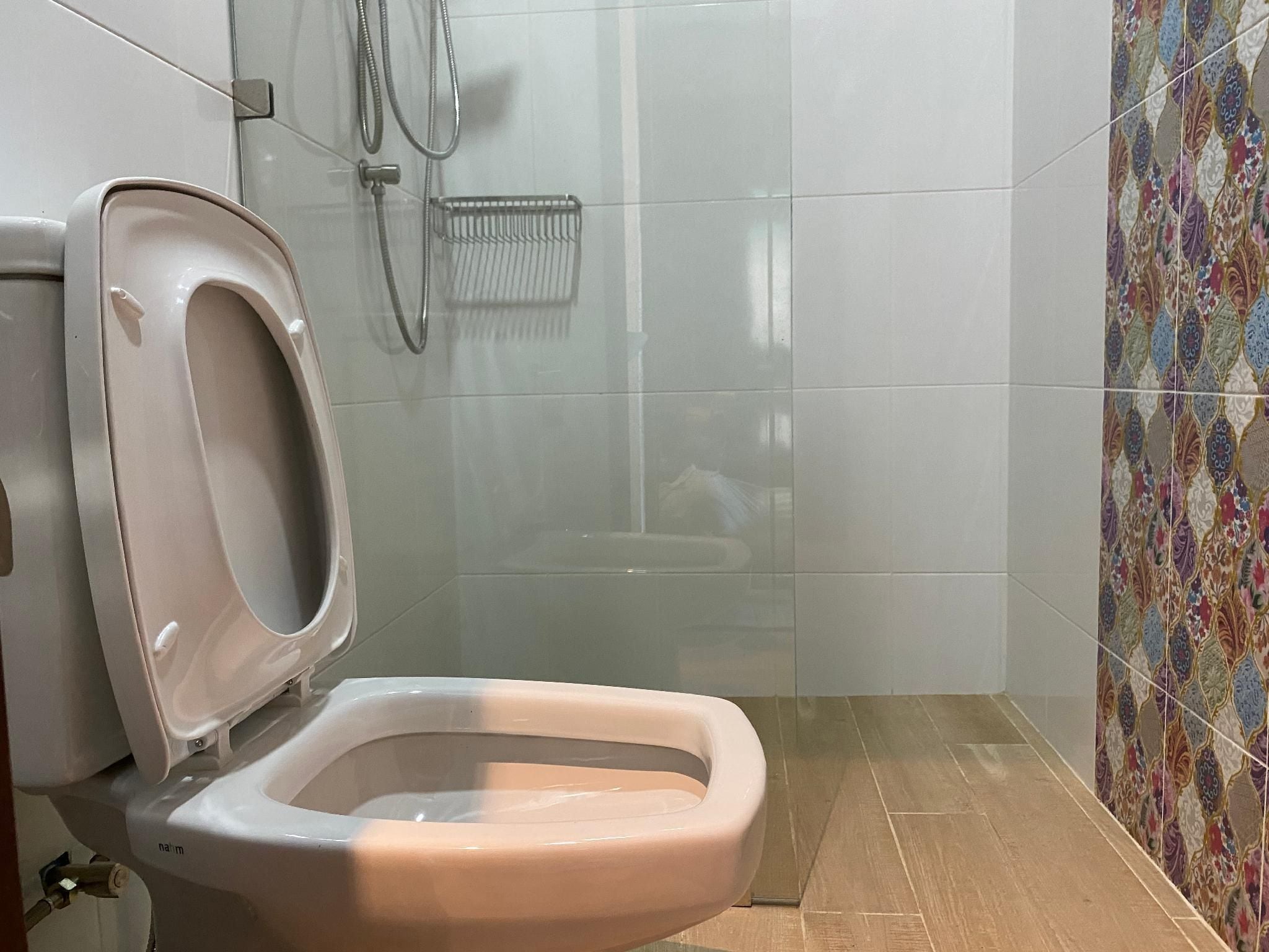 Inodoro con asiento elevado y bidé instalado en la pared.