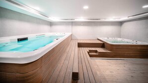 Un espace bien-être comprenant deux bains à remous et un sol en bois.