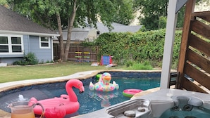 A backyard with a hot tub, inflatable flamingos, and a swimming pool. - 4bd 3ba - Pool / HotTub/ Arcade/ Theater/ PingPong/ Foosball (Pflugerville)