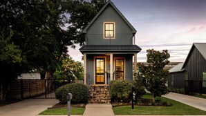 A two-story house with a gabled roof, a front porch, and a stone foundation.