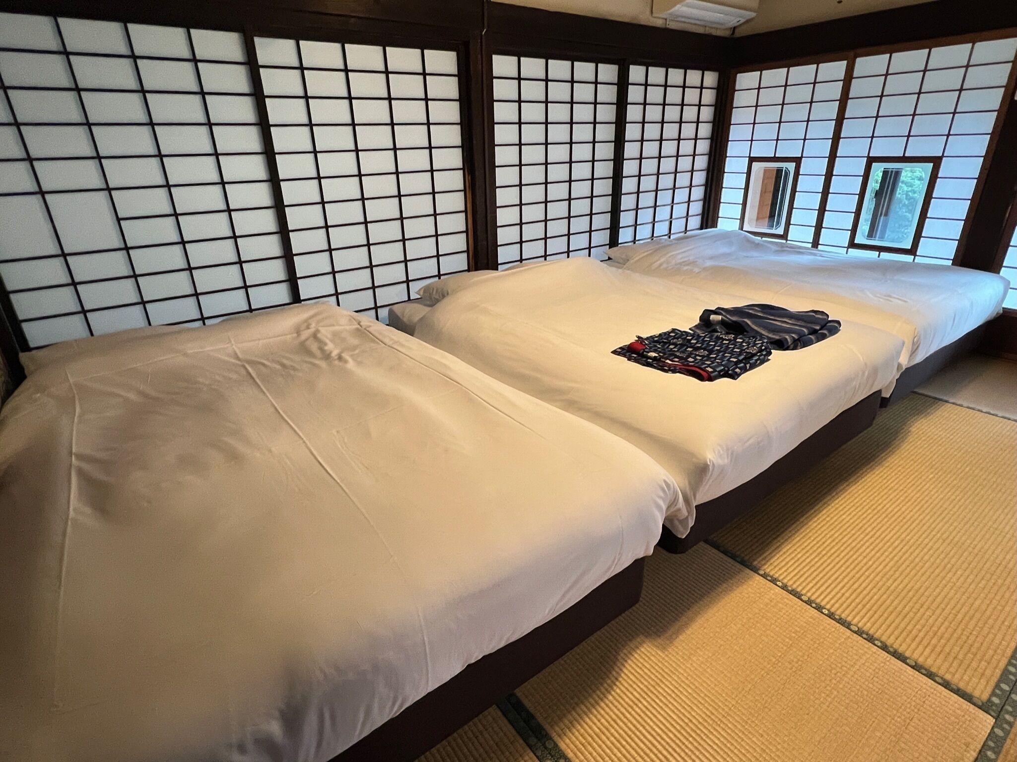 Ett traditionellt japanskt rum med tatamimattor på golvet, två tatamimattor och en vägg av skjutpaneler (shoji).