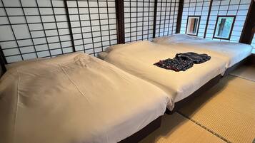 A traditional Japanese-style room with tatami flooring, two tatami mats, and a shoji screen wall.