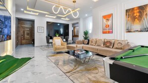 A modern living room with a pool table, a sofa, and a chandelier. - Ocean view Luxurious 2 bedroom apartment on Lekki phase 1. Close to all beaches (Lekki)