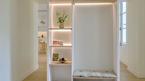 Un vestidor moderno y bien iluminado, con múltiples estantes y un zapatero.