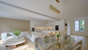 Una cocina moderna con armarios blancos, una isla central e iluminación colgante.