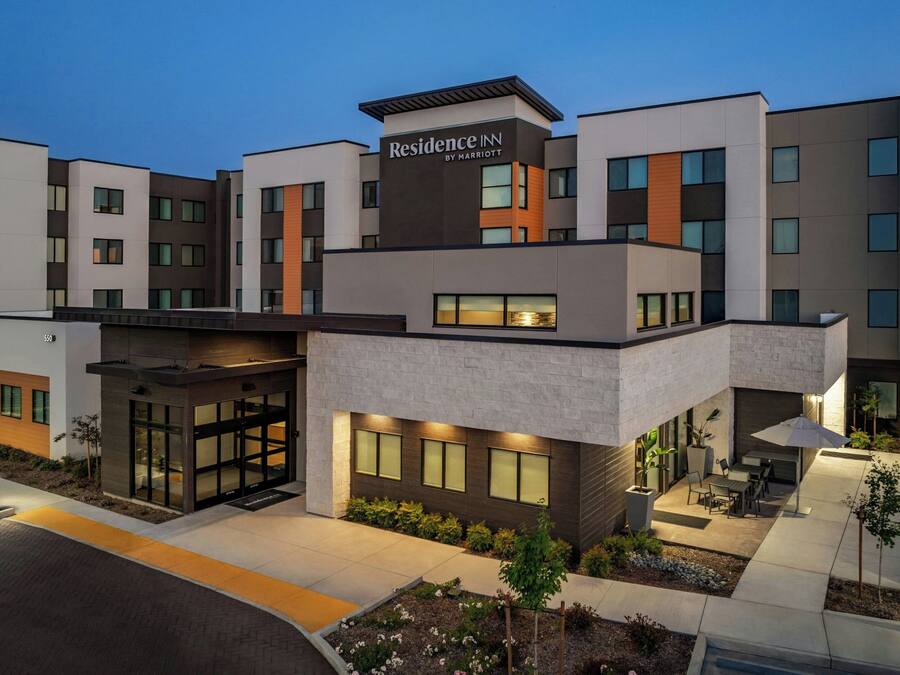 A modern hotel with a flat roof, large windows, and a sign reading "Residence Inn by Marriott".