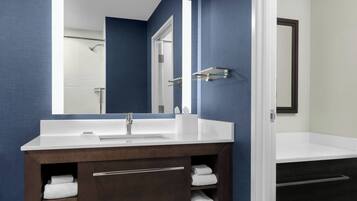 Une salle de bain moderne avec un meuble-lavabo à deux vasques, des meubles en bois foncé et un grand miroir.