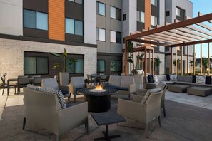 An outdoor patio with wicker furniture, a central fire pit, and a pergola. - Residence Inn by Marriott Sacramento Cal Expo (Sacramento)