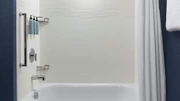 A modern bathroom with a white bathtub, a showerhead, and a towel rack.