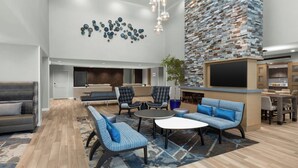 A spacious lobby with a seating area, a fireplace, and a kitchen area. - Residence Inn by Marriott Sacramento Cal Expo (Sacramento)