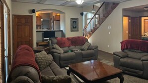 A living room with a sofa set, a coffee table, and a staircase. - Gorgeous Executive Home - Hot Tub, Gym, Theatre, and More! (Spokane)