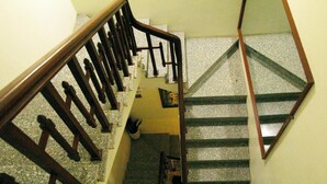 Un escalier avec des rampes et une main courante en bois, menant à l’étage supérieur.