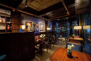 A cozy bar area with wooden furniture, a coffee machine, and a vase with flowers. - Nexus House Nguyen Binh Khiem - Near Saigon Zoo & Botanical Gardens (Ho Chi Minh City)