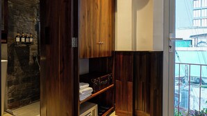 Un bagno moderno con un mobile bagno in legno, una parete decorativa in pietra e una porta in vetro che dà su un balcone.