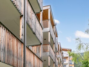 Monikerroksinen rakennus, jossa on parvekkeita ja puinen julkisivu.