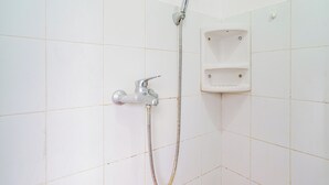 Eine Dusche mit Handbrause und fest installiertem Wasserhahn.