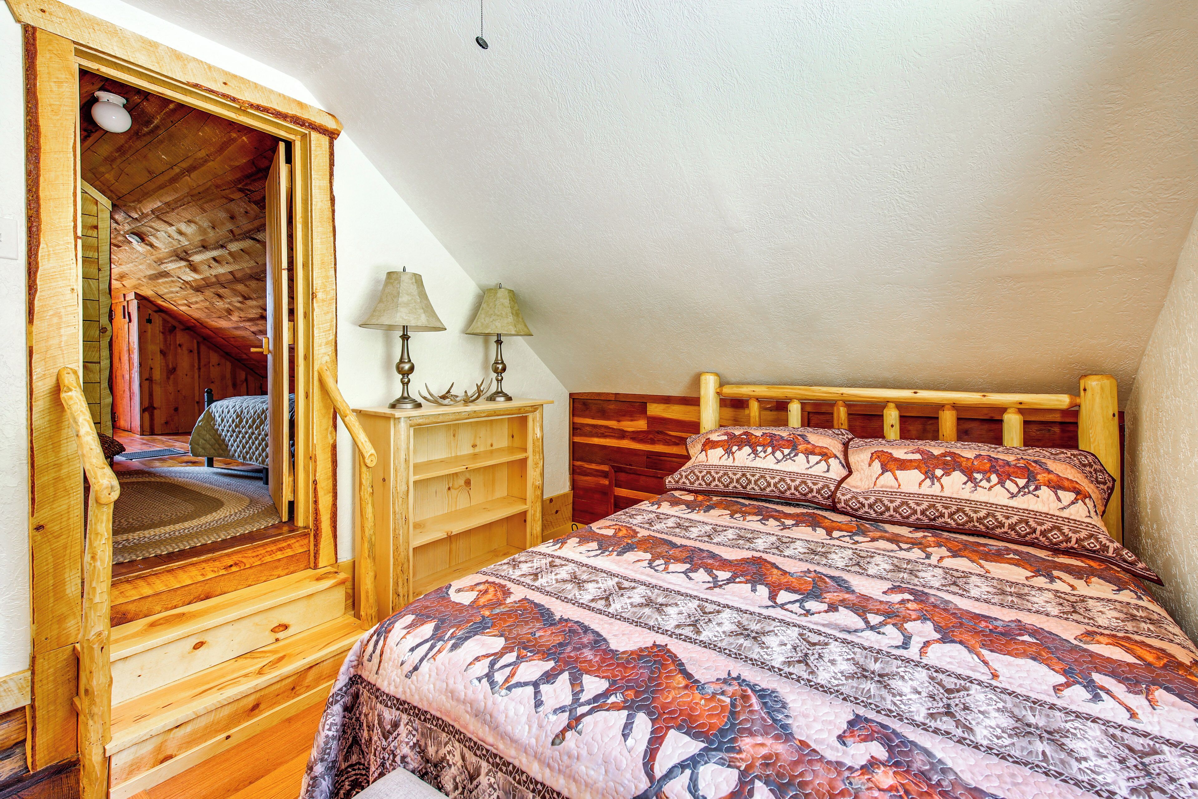 Een gezellig slaapkamer op zolder met een houten bed, een klein bureau en een stoel.