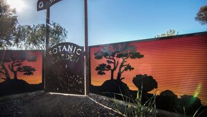 A sign for 'Botanic Garden' with a silhouette of trees and a sun.