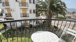 A balcony with a round table and chairs, surrounded by a metal railing. - Flat El Retiro 4 people with swimming pool. (Dénia)
