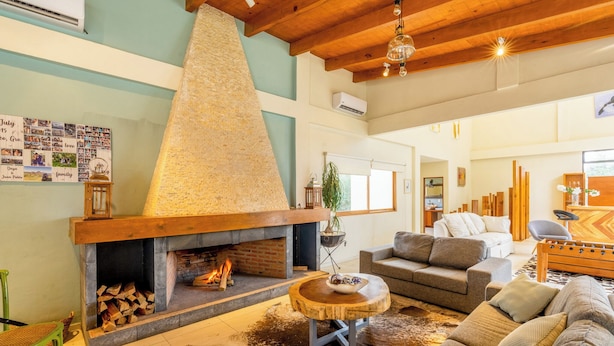 A cozy living room with a fireplace, a sofa set, and a dining area with a wooden table. - Scenic Haven Cozy Pet Friendly Retreat (Mexico City)