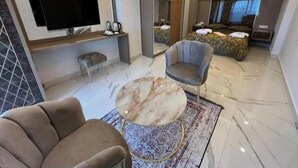 A modern living room with a flat-screen TV, a round coffee table, and a comfortable sofa. - Alp Ateş Suit  (Ayvacik)