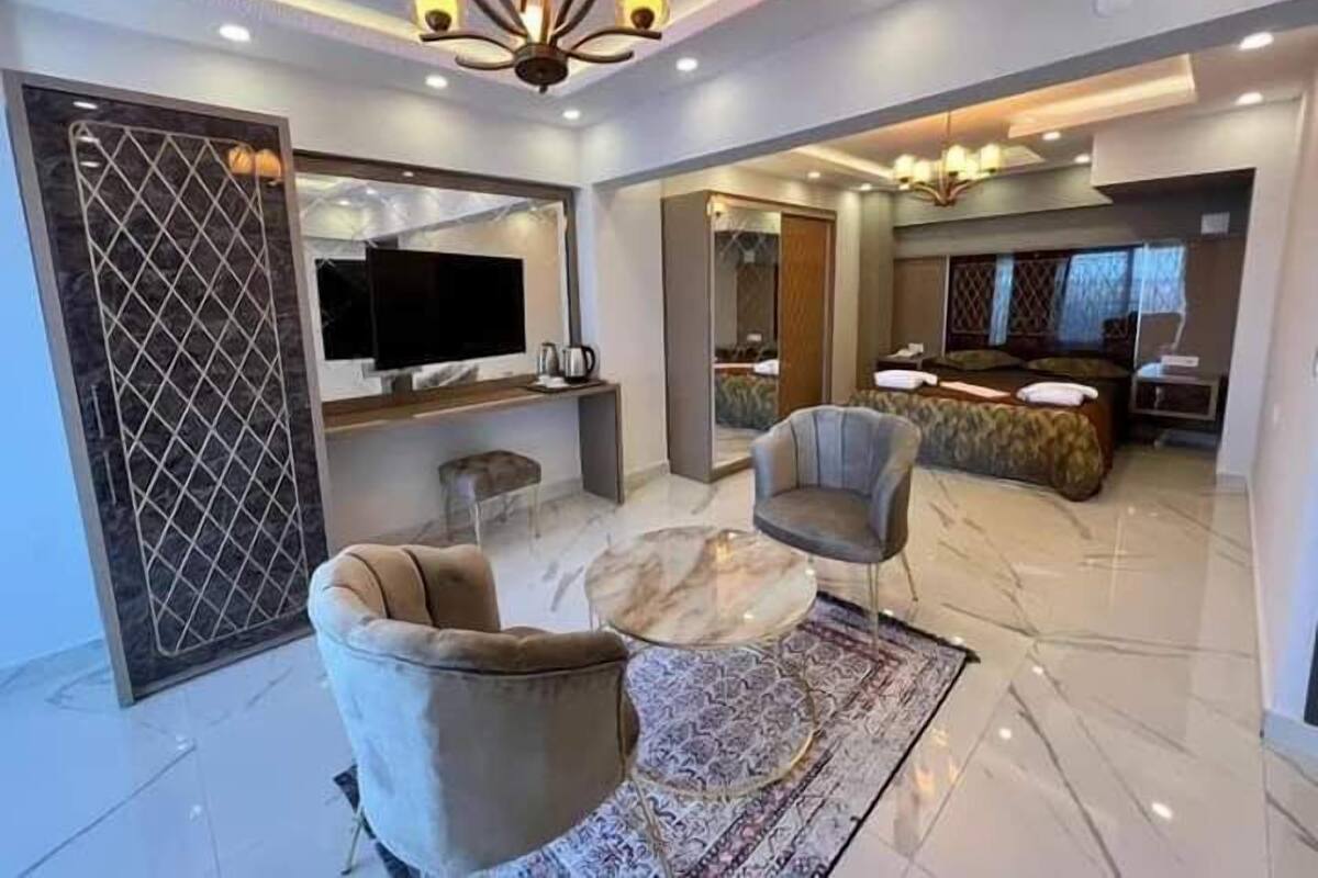 A modern living room with a marble floor, a large TV, a sofa, and a coffee table.