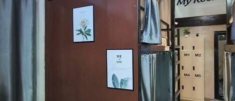 A room with a brown cabinet, a bed with a grey cover, and a door labeled "My Room".