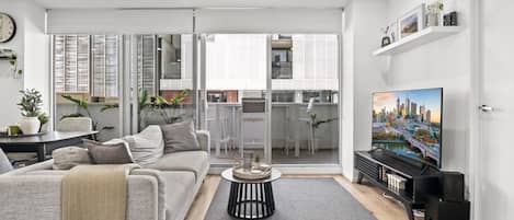 A modern living room with a sofa, coffee table, and a flat-screen TV.