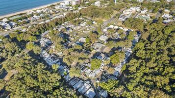 An aerial view of a residential area with houses, roads, and a beach.