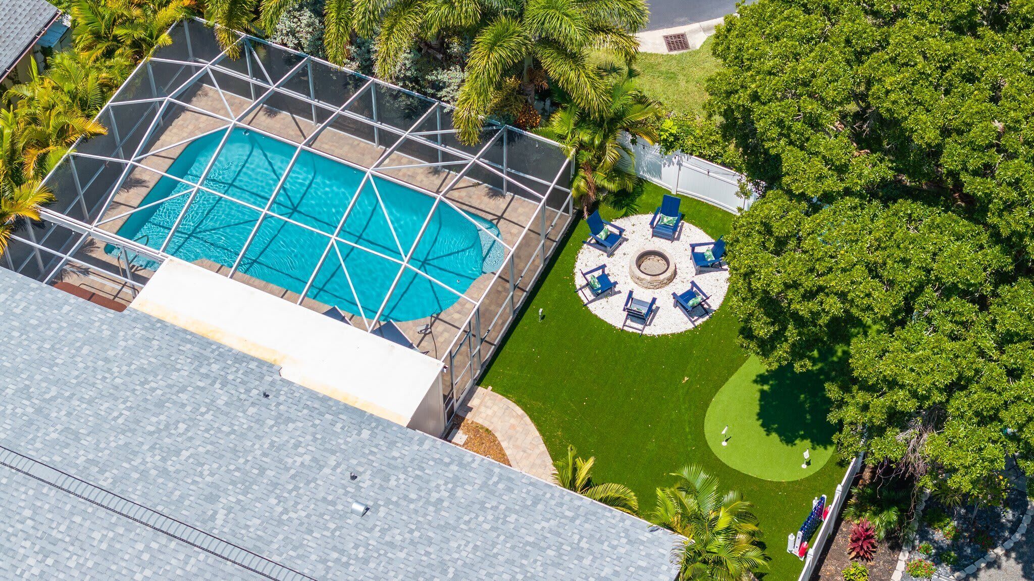 Vue aérienne d’une piscine sur le toit, avec un espace barbecue et des chaises longues.